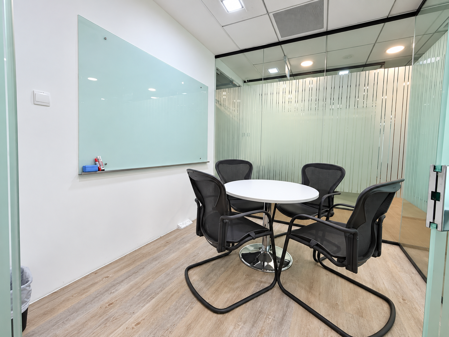 Small meeting room with round table and four chairs